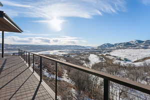 Snow covered back of property featuring a mountain view