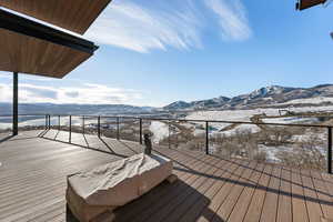 Snow covered deck featuring a mountain view