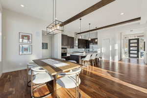 Dining space featuring beamed ceiling and dark hardwood / wood-style flooring