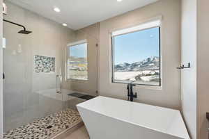 Bathroom featuring a mountain view, plus walk in shower, a healthy amount of sunlight, and tile patterned flooring