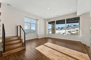 Unfurnished living room with a mountain view and dark hardwood / wood-style flooring