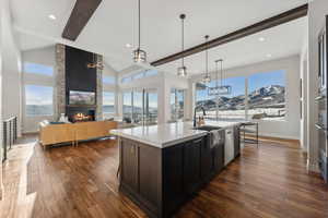 Kitchen with a mountain view, a center island with sink, a wealth of natural light, and hanging light fixtures