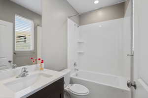 Full bathroom with vanity, shower / bath combination, and toilet