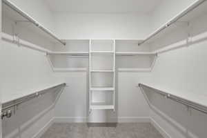 Spacious closet with light colored carpet