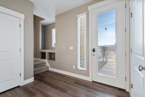 Doorway to outside featuring dark hardwood / wood-style floors and a wealth of natural light