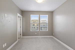 Carpeted spare room with a textured ceiling