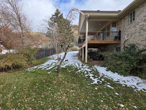 Yard layered in snow with a wooden deck