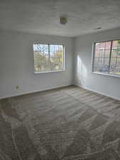 Bedroom 1 featuring carpet flooring and a textured ceiling