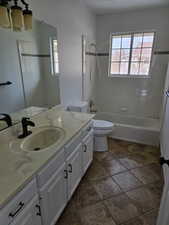 Full bathroom with vanity, toilet, and tiled shower / bath