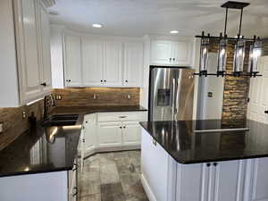 Kitchen featuring white cabinetry and stainless steel fridge with ice dispenser