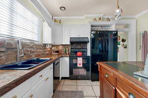 Kitchen featuring white cabinetry, sink, tasteful backsplash, crown molding, and black appliances