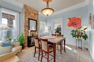 Dining room with a fireplace, light tile patterned floors, and a wealth of natural light