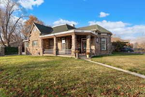 View of front of home with a porch and a front lawn