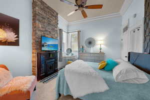 Carpeted bedroom featuring ceiling fan and crown molding