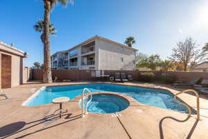 View of swimming pool featuring a patio area and a hot tub