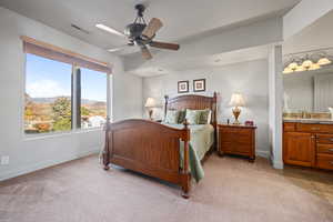 Carpeted bedroom with connected bathroom, a mountain view, sink, and ceiling fan