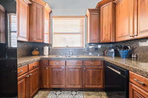 Kitchen featuring decorative backsplash, sink, and black dishwasher