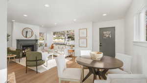 Dining space featuring light wood-type flooring and a high end fireplace