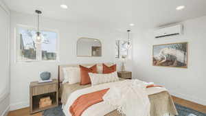 Bedroom featuring hardwood / wood-style floors and a wall mounted air conditioner