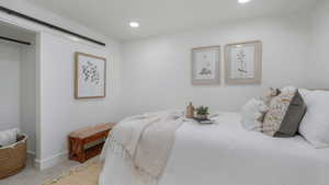 Carpeted bedroom featuring a barn door