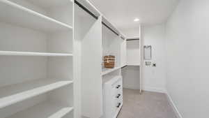 Walk in closet with light colored carpet