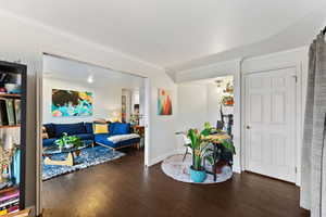 Interior space with dark hardwood / wood-style floors and ornamental molding