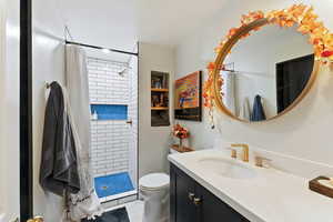 Bathroom with tile patterned floors, a shower with curtain, vanity, and toilet