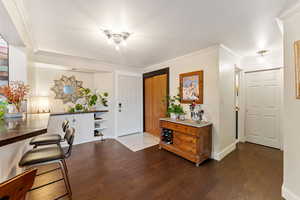 Entrance foyer featuring dark hardwood / wood-style flooring and ornamental molding