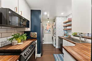 Kitchen with white cabinets, dark hardwood / wood-style floors, butcher block counters, and range