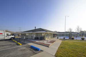 View of front of property with a front lawn and central AC