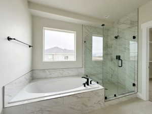 Full bathroom with a marble finish shower and a bath