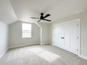 Bonus room featuring ceiling fan, baseboards, vaulted ceiling, and light colored carpet