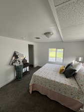 Bedroom with dark carpet, visible vents, and baseboards