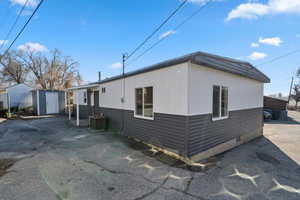 View of side of property with central AC and a shed