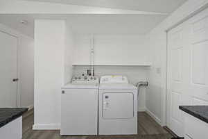 Clothes washing area featuring washer and clothes dryer and dark hardwood / wood-style floors