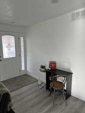 Entrance foyer featuring baseboards, visible vents, and wood finished floors
