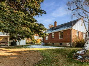 View of property exterior with a patio area and a lawn