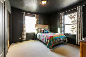 Carpeted bedroom with a textured ceiling