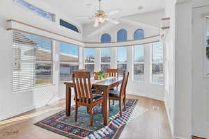 Dining space featuring ceiling fan, vaulted ceiling, and light hardwood / wood-style flooring