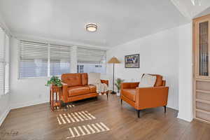 Sitting room featuring wood-type flooring and a healthy amount of sunlight