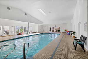 View of swimming pool featuring a skylight