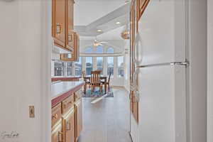 Kitchen featuring light wood-type flooring, white refrigerator, and lofted ceiling