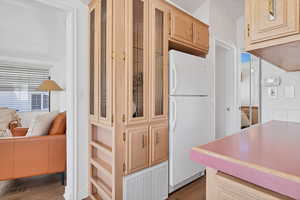 Kitchen featuring dark hardwood / wood-style flooring, white fridge, and light brown cabinets