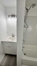 Bathroom featuring shower / tub combination, vanity, and wood-type flooring