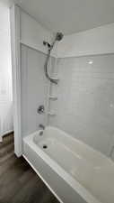 Bathroom featuring hardwood / wood-style floors and tiled shower / bath