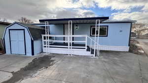 Back of property with a porch and a storage shed