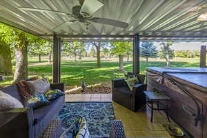 View of patio with outdoor lounge area, ceiling fan, and a hot tub