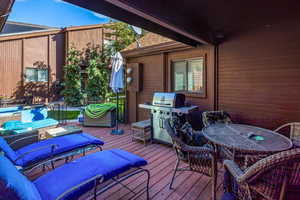 Wooden terrace with an outdoor hangout area and grilling area