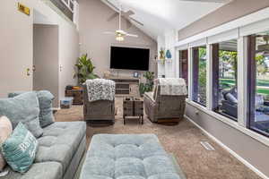 Living room featuring carpet flooring, ceiling fan, and lofted ceiling