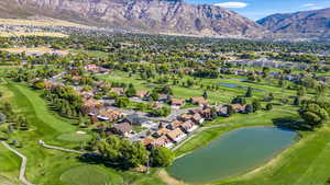 Drone / aerial view with a water and mountain view and Golf Course